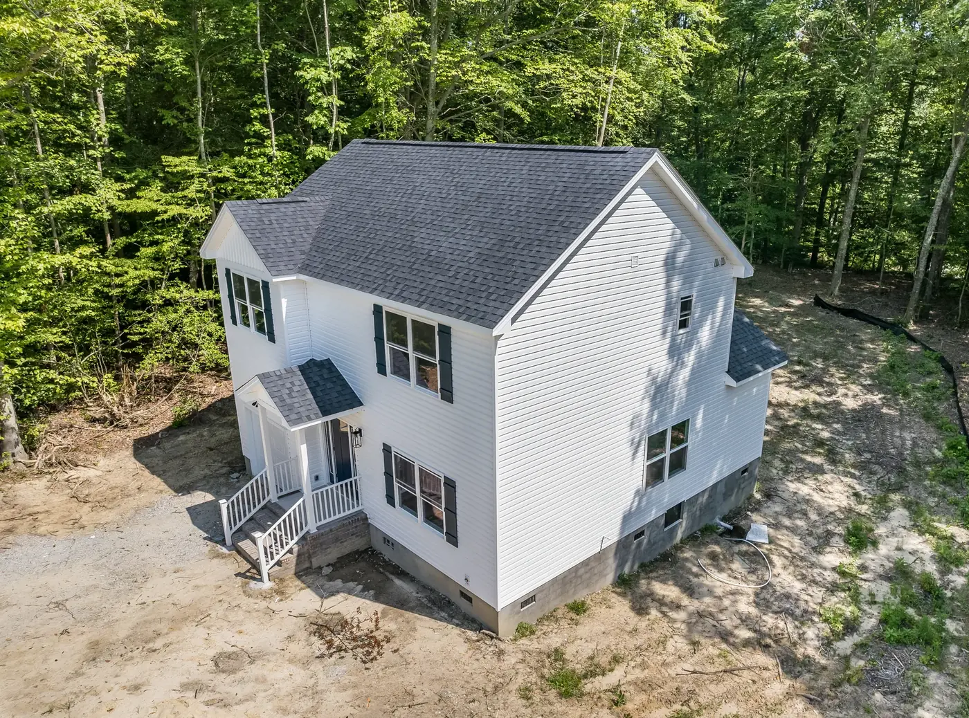 Newly built two-storey home with fresh siding, porch and steps