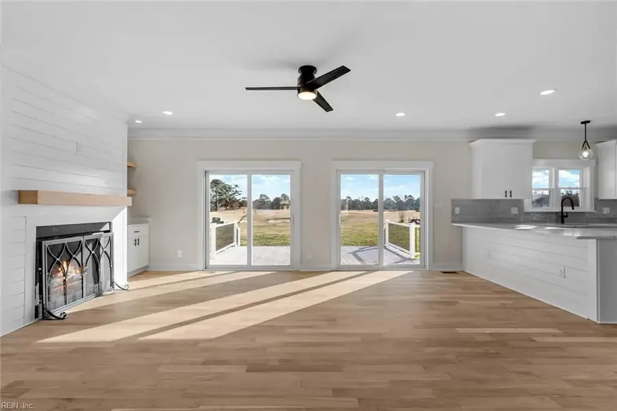 Open-plan living room and kitchen with fireplace and sliding doors to the rear