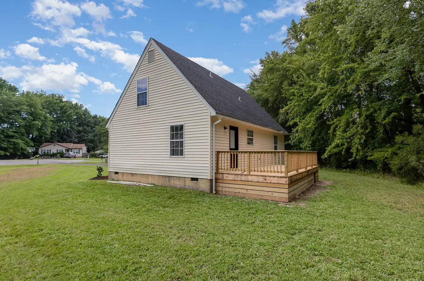 Rear addition with new siding and an attached deck with railings
