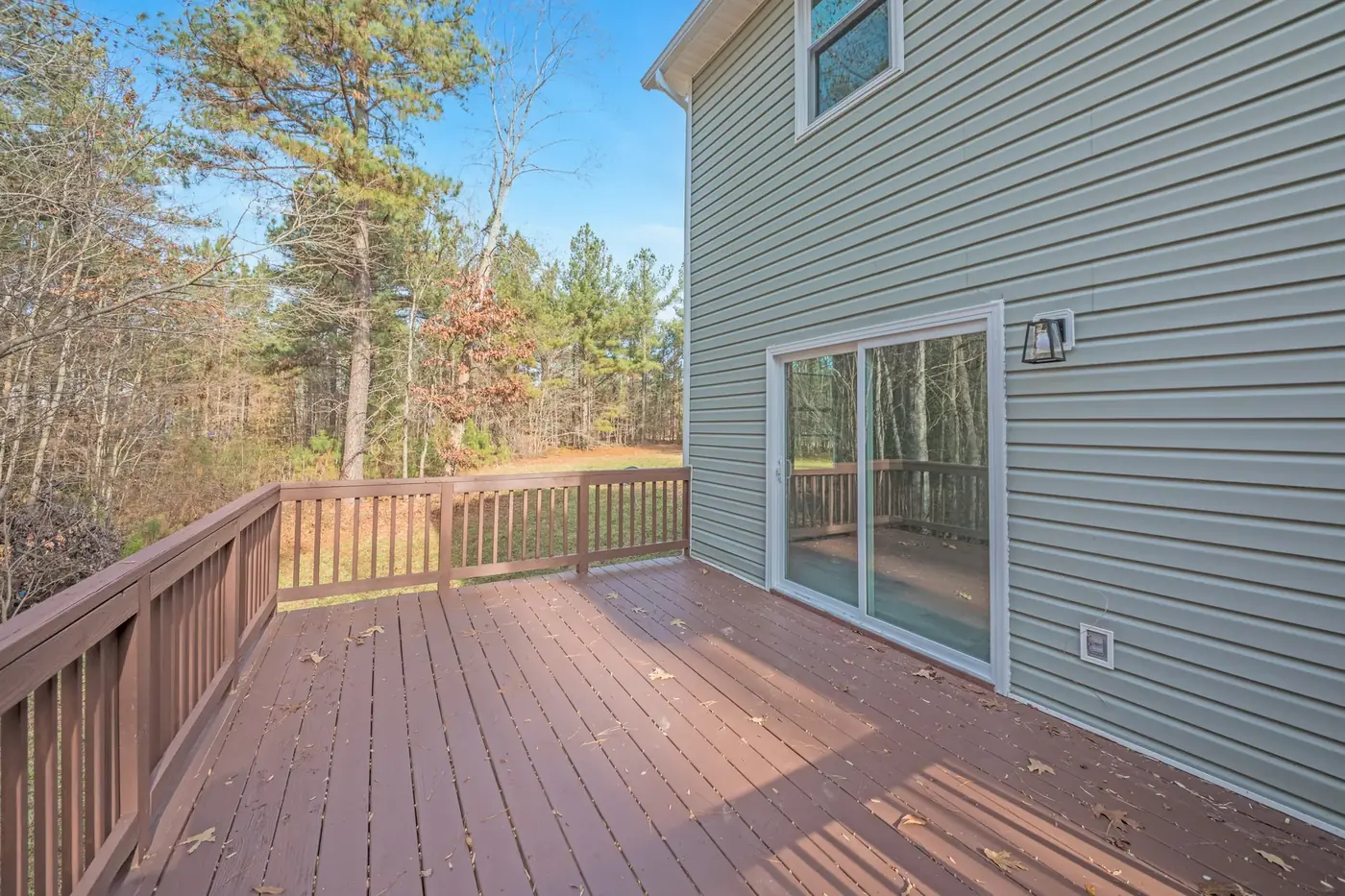 Composite rear deck with railings overlooking a back yard