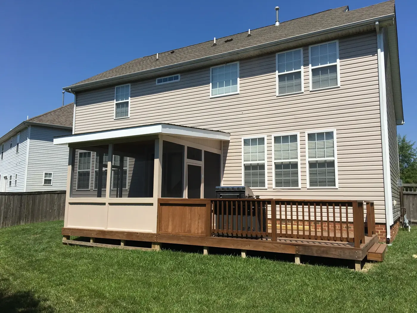 Screened porch addition alongside an open deck with railings
