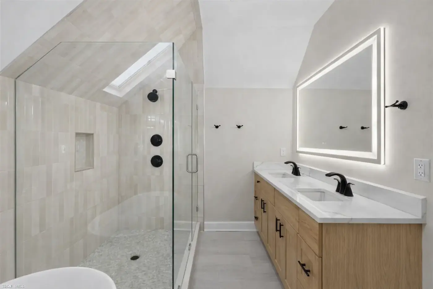 Renovated bathroom with white shaker vanity, quartz top and framed mirror