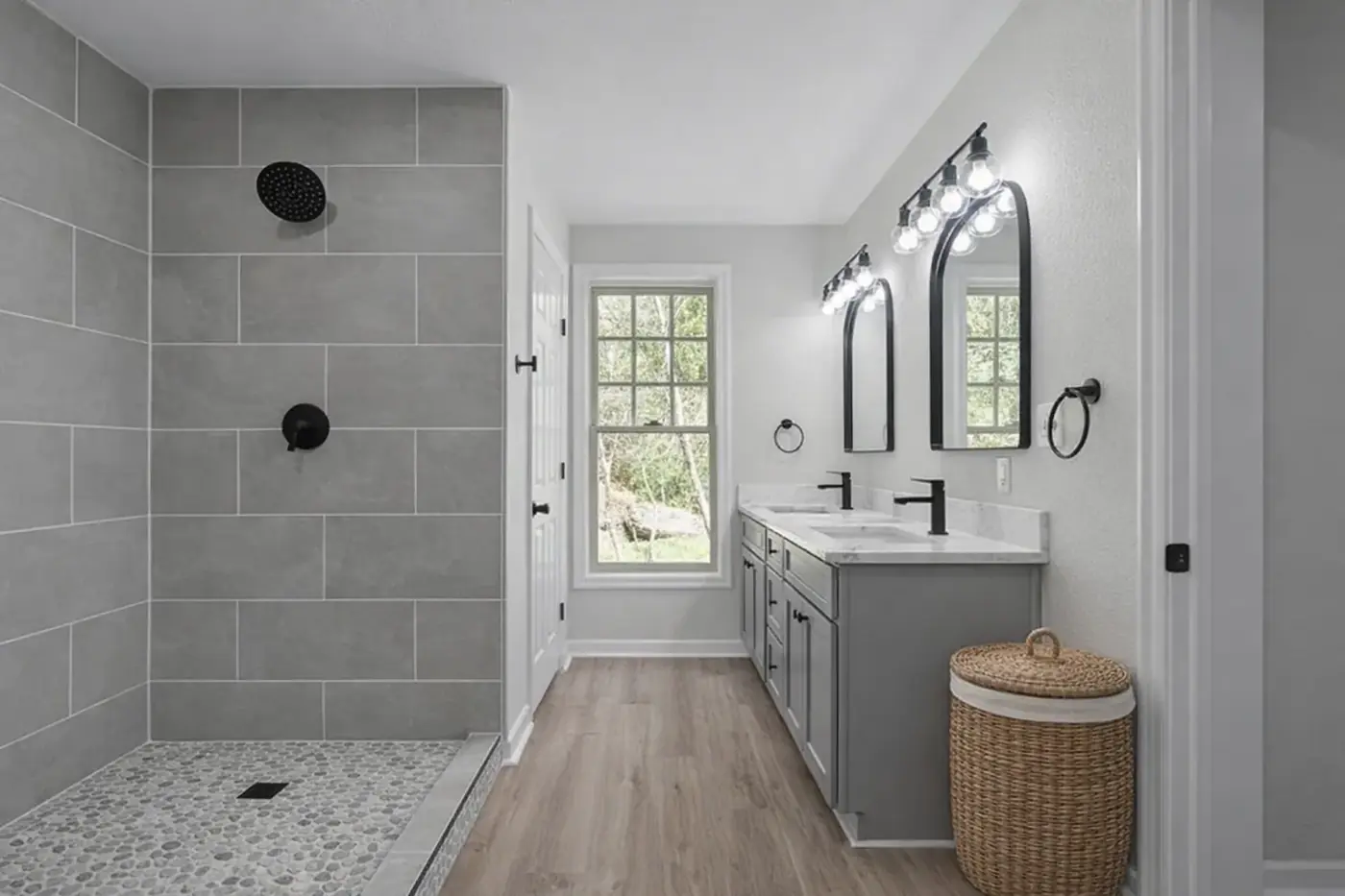 Renovated bathroom with double vanity, patterned tile floor and framed mirrors