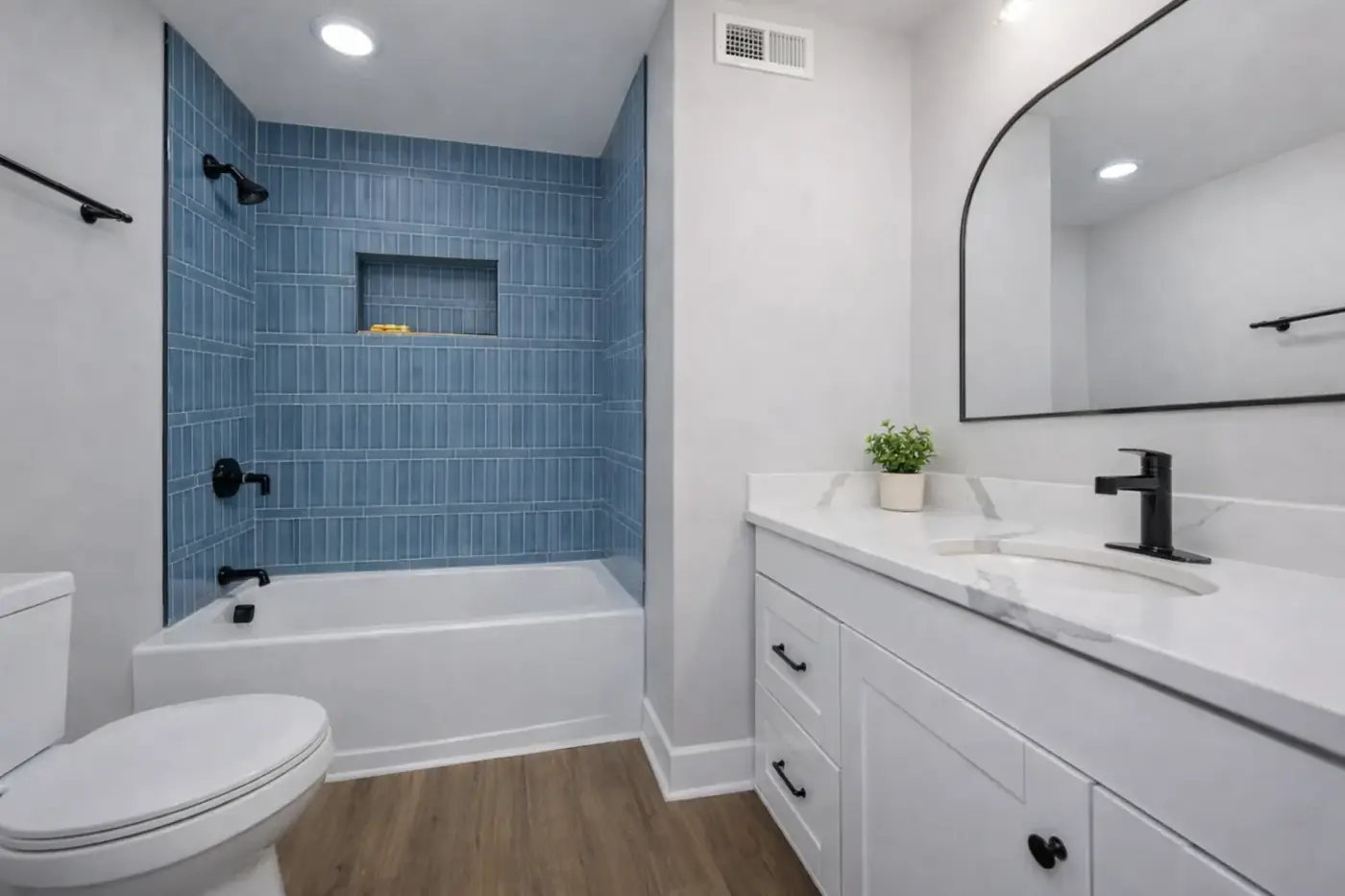 Bathroom with tiled tub and shower surround and a floating vanity