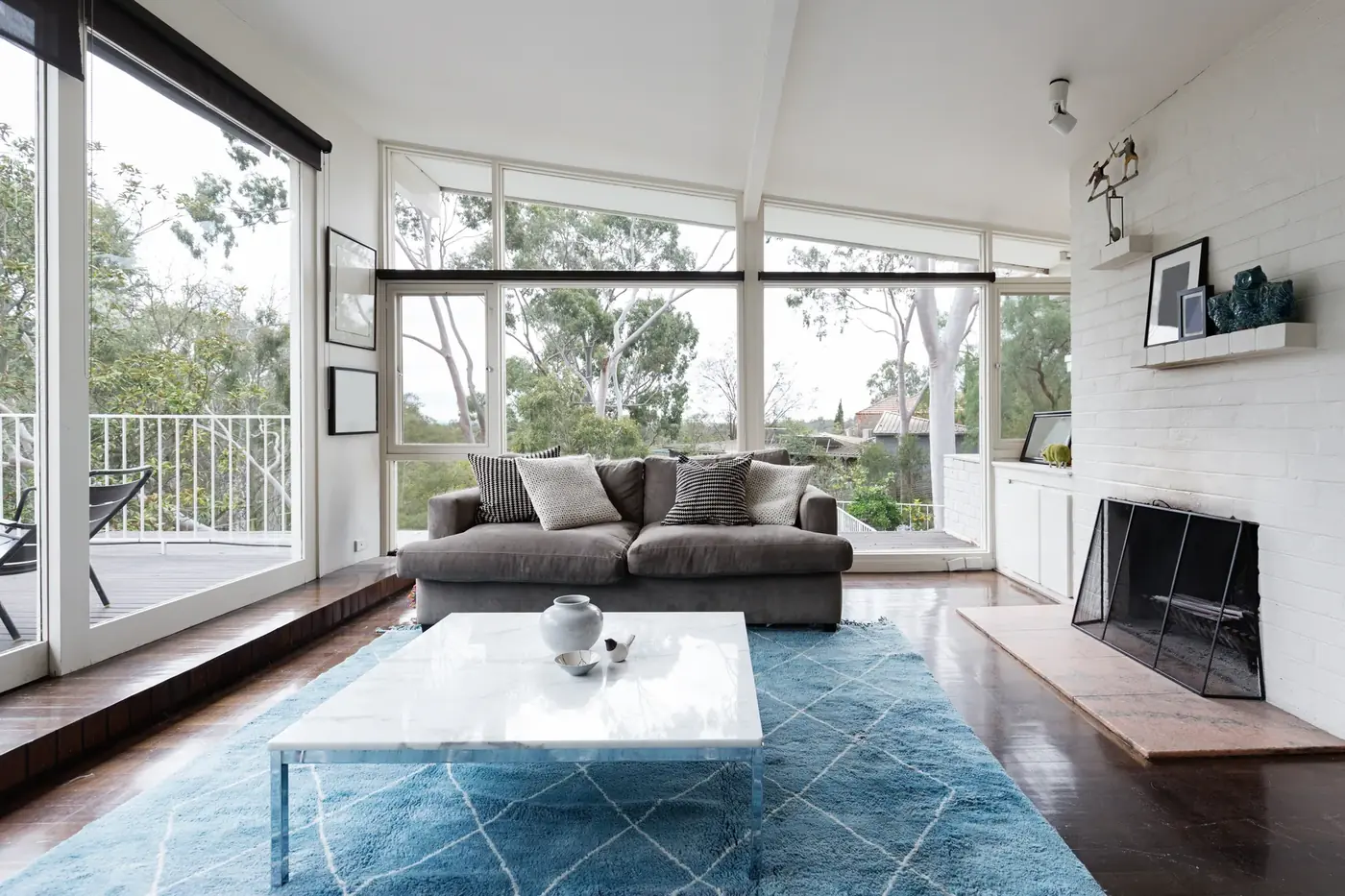 Living room with large windows and a low fireplace used as a design reference image