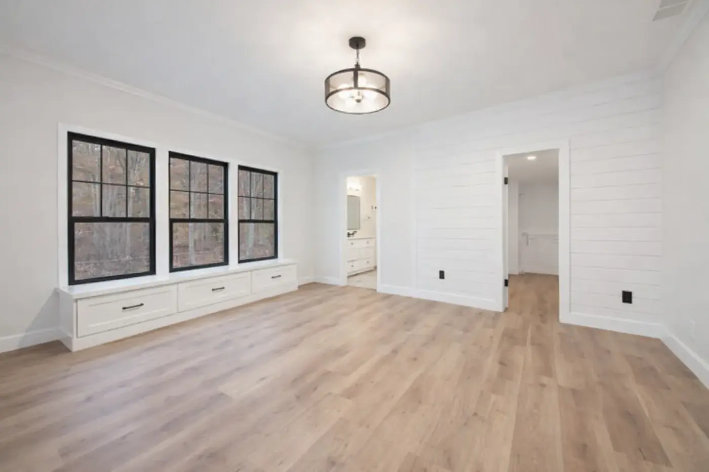 Remodelled living space with black-framed windows, white walls and wood floors
