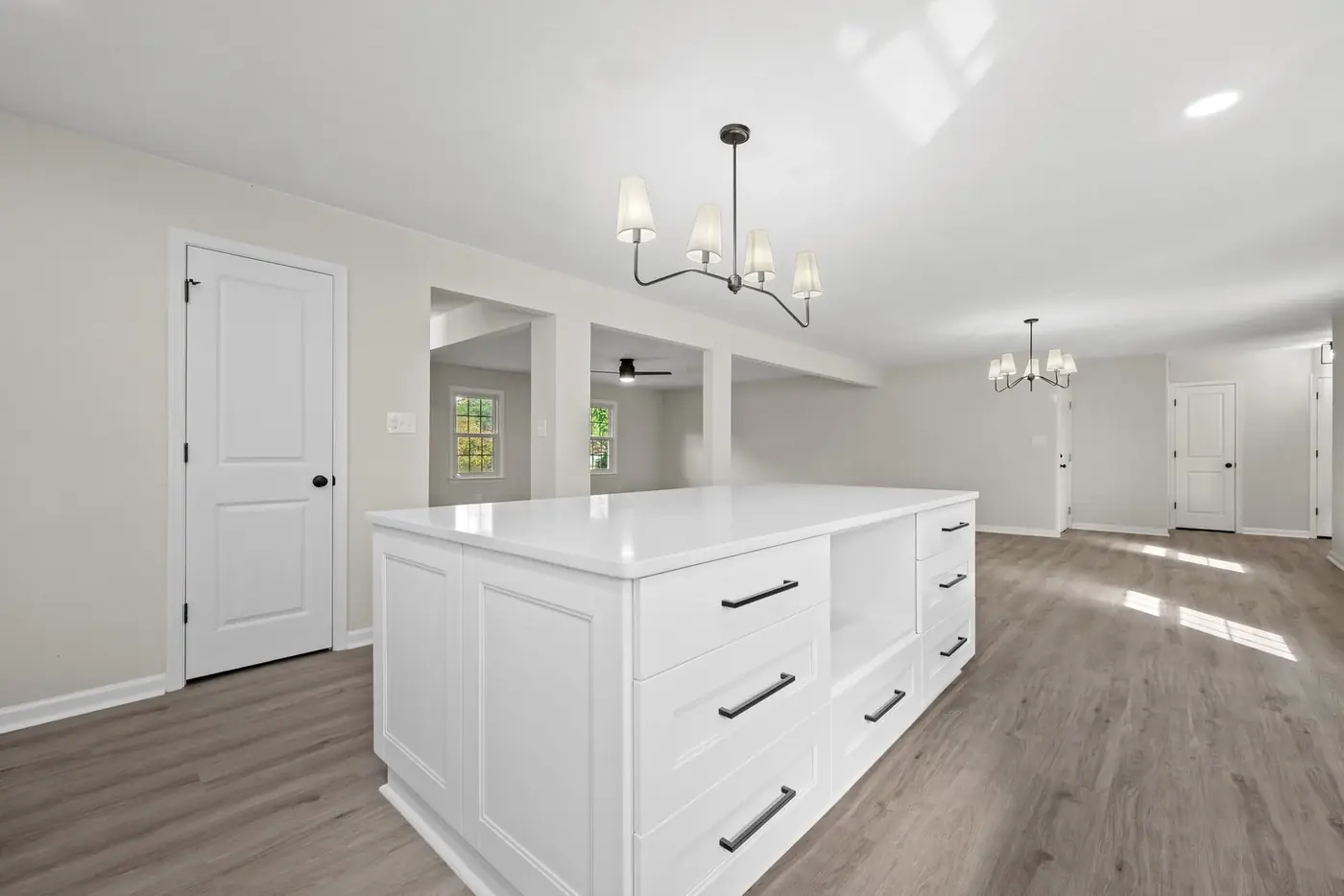 Kitchen and great room after renovation with island seating and new lighting