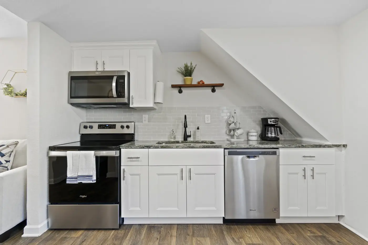 Renovated kitchen with sage cabinetry, quartz counters and stainless appliances