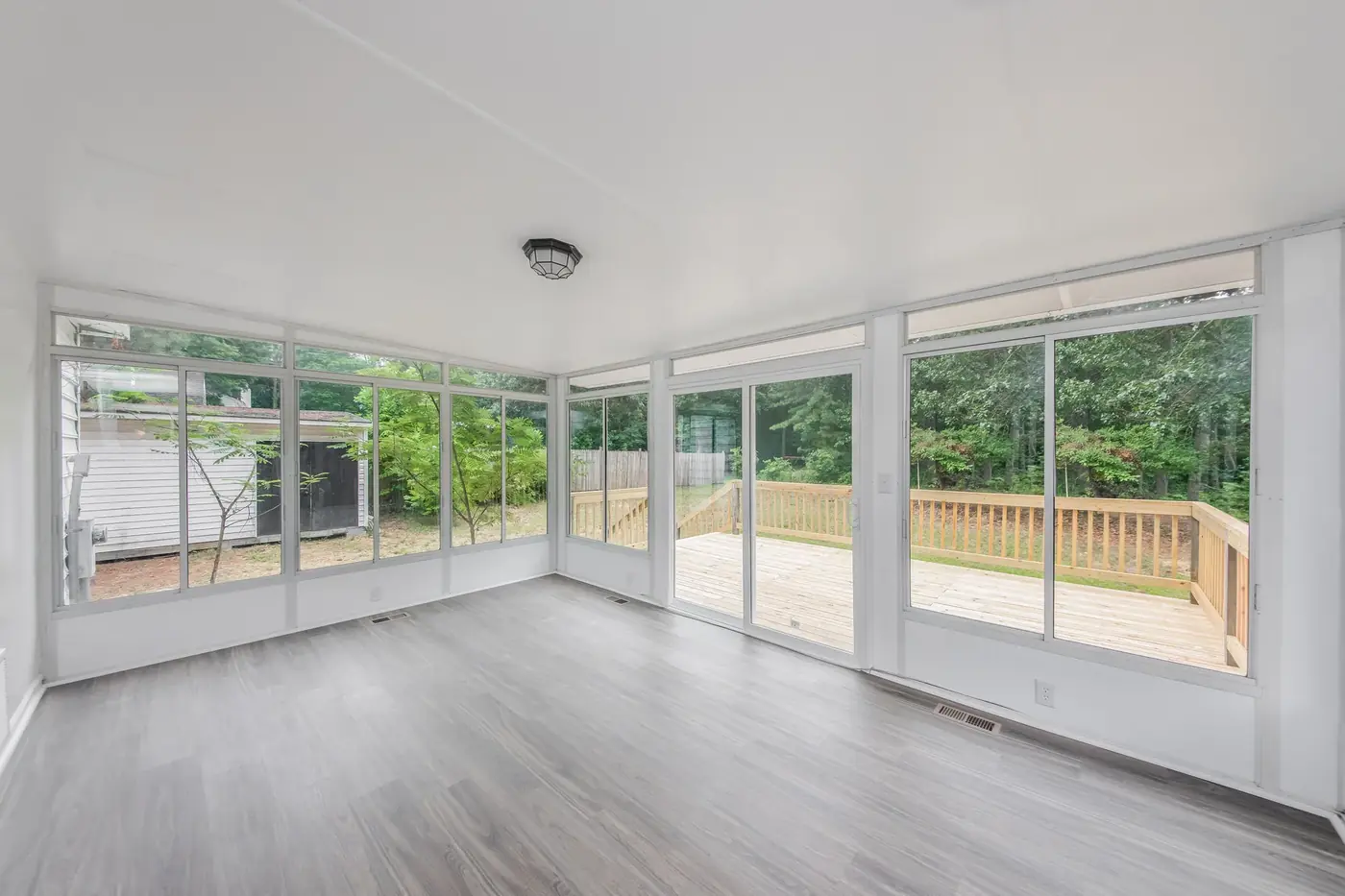 Kitchen renovation with white cabinetry, island and hardwood-look flooring