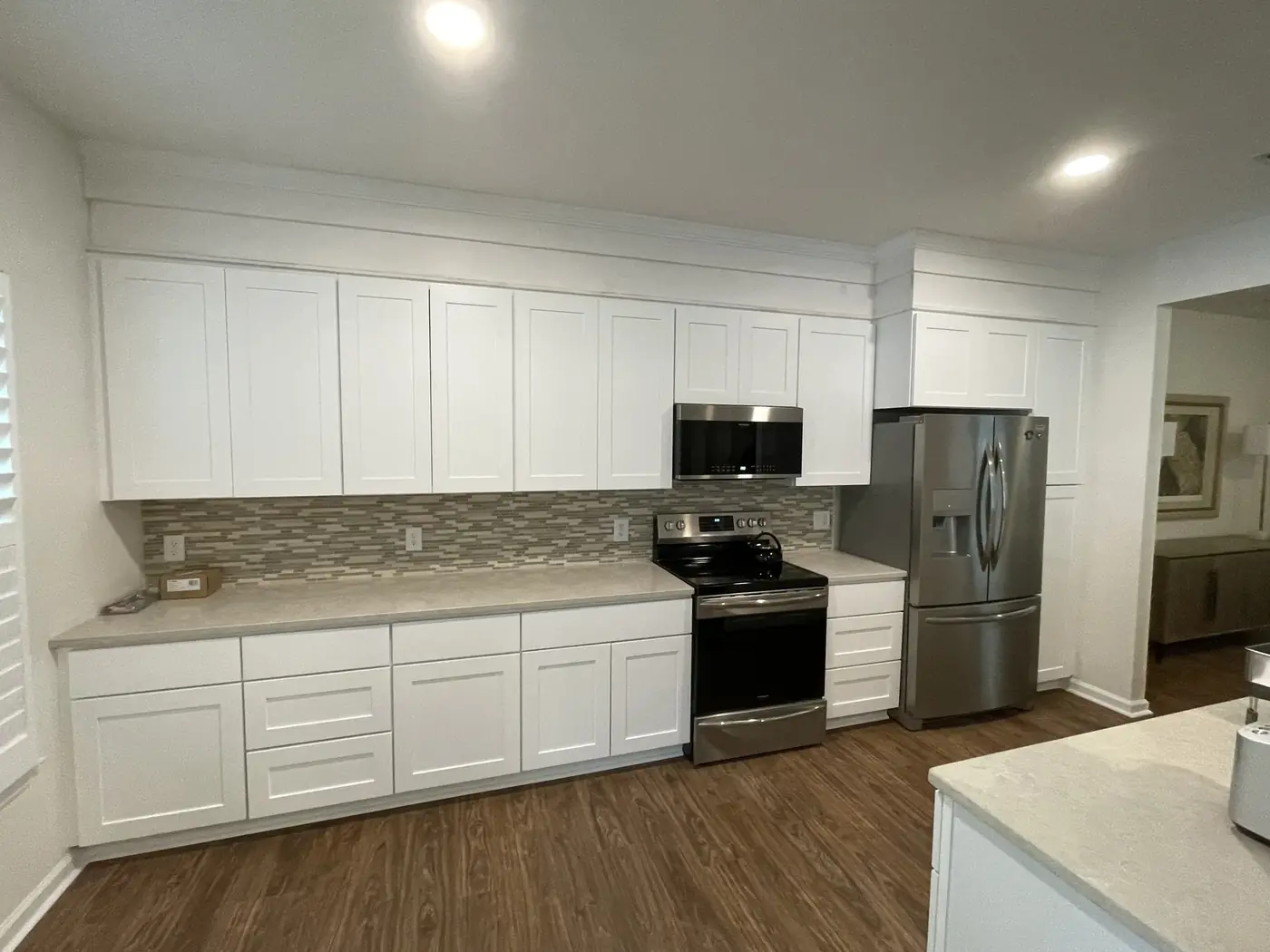 Kitchen with white cabinetry, tile backsplash and stainless appliances installed