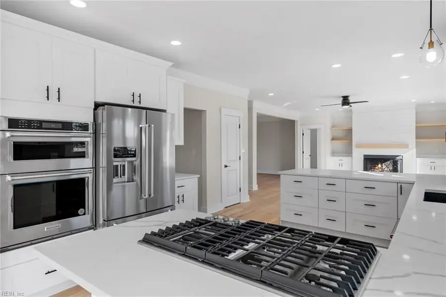 Kitchen with gas range, white cabinetry and a full-height pantry wall